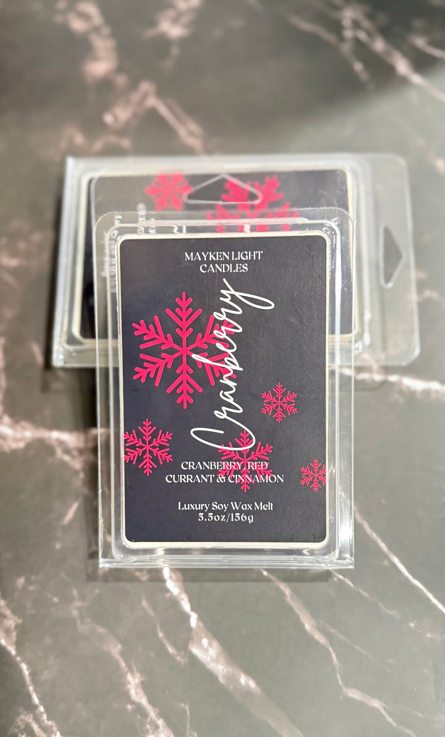 Packaged wax melt with snowflake design on a marble surface