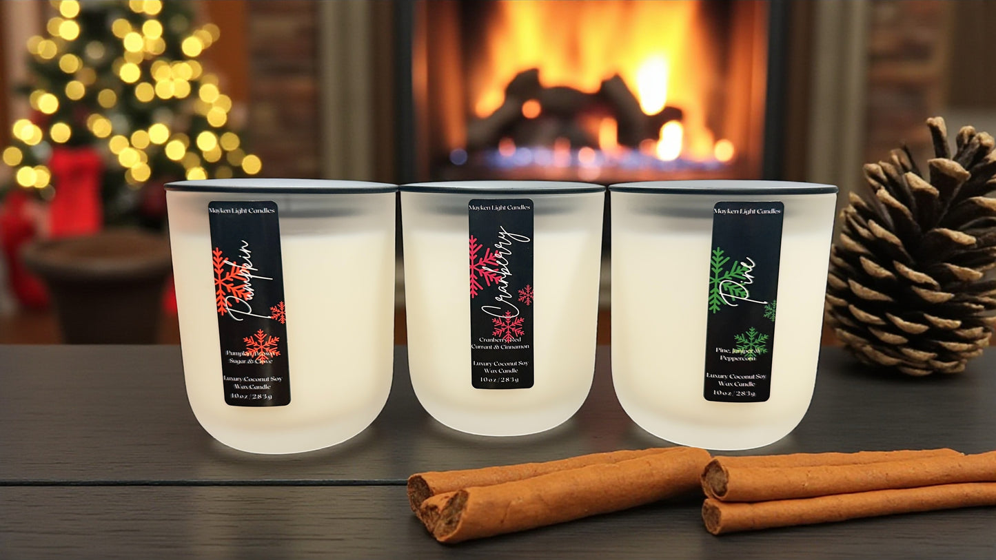 Three lit candles with labels on a table in front of a fireplace.
