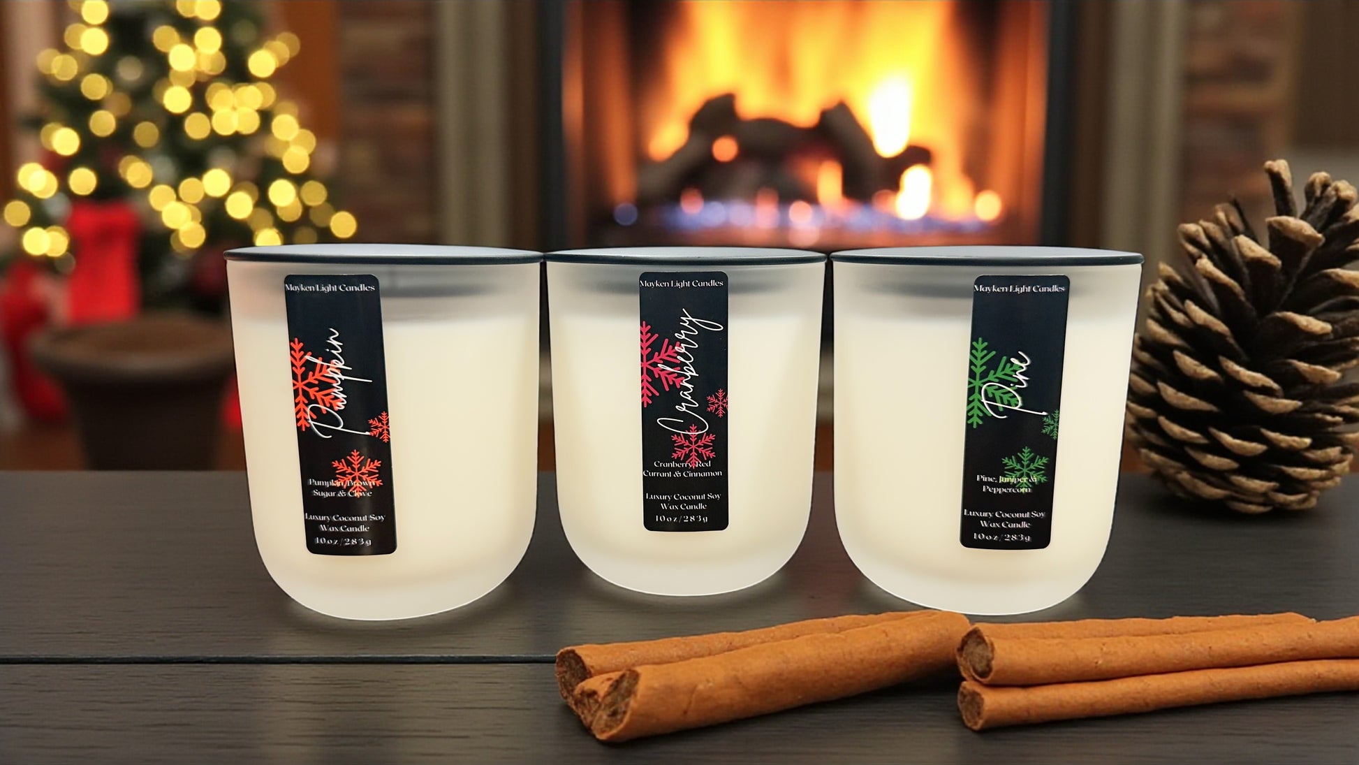Three lit candles with labels on a table in front of a fireplace.